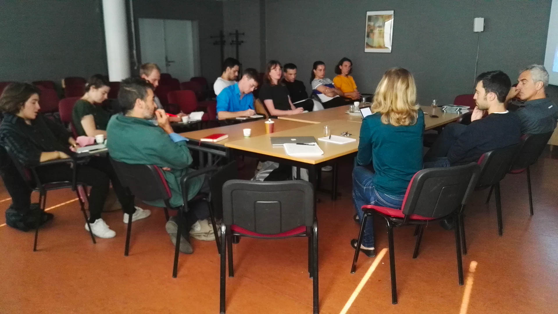 Personnes réunies autour d'une grande table et discutant.