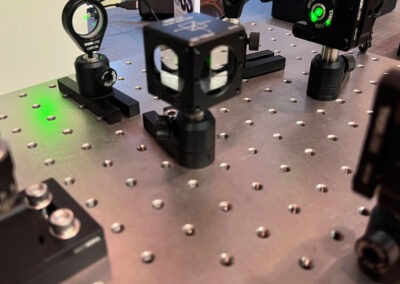 Interféromètre de Michelson pédagogique : dispositif optique avec laser vert illustrant le principe de détection des ondes gravitationnelles par interférence lumineuse.