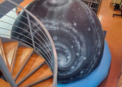 Planétarium du Outreach Centre installé dans la bibliothèque de physique de l'Université Paris Cité. Vue d'ensemble montrant le dôme immersif entouré d'étagères scientifiques au cœur du laboratoire APC.
